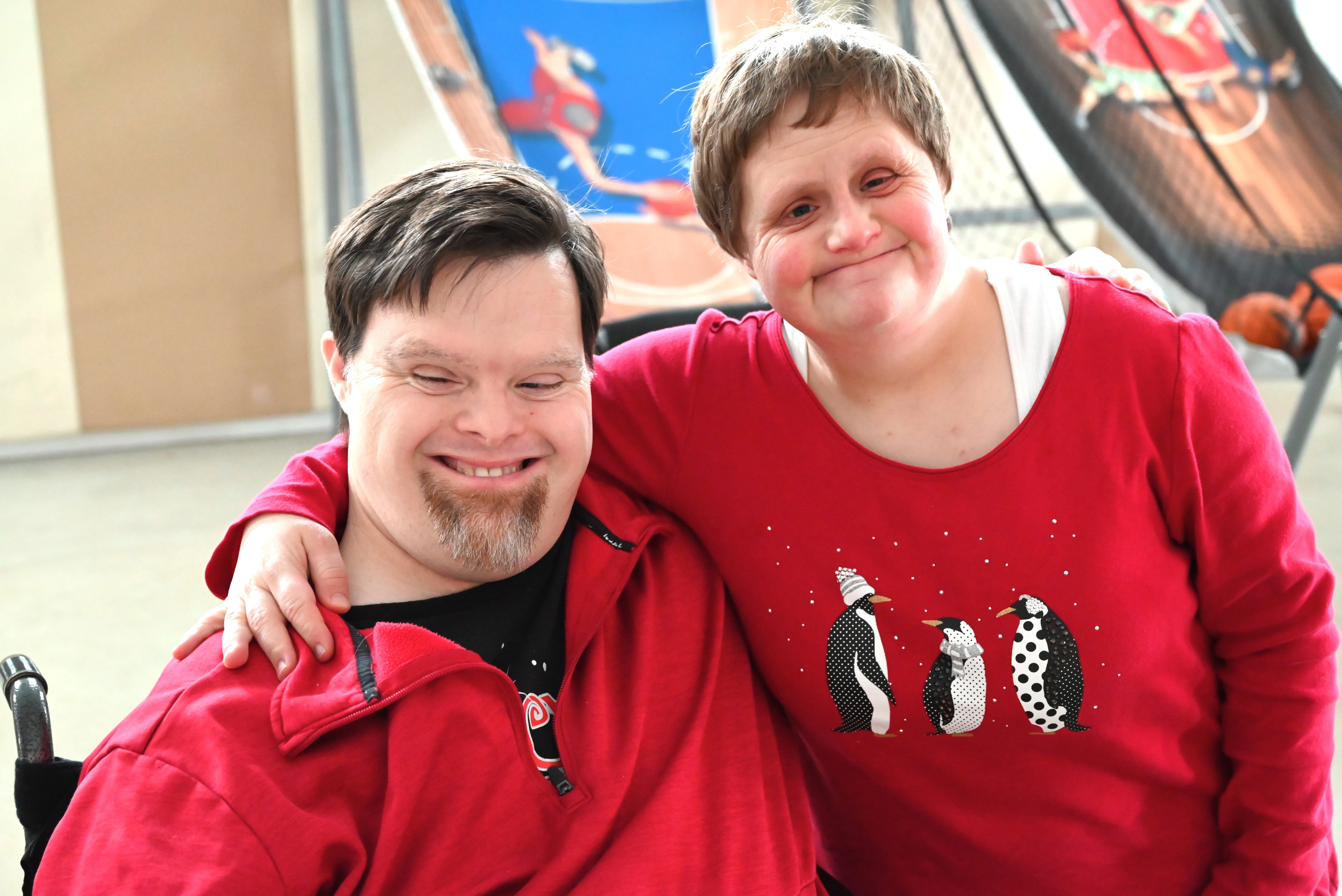 Sam Closser and his friend are smiling, both in matching festive red shirts