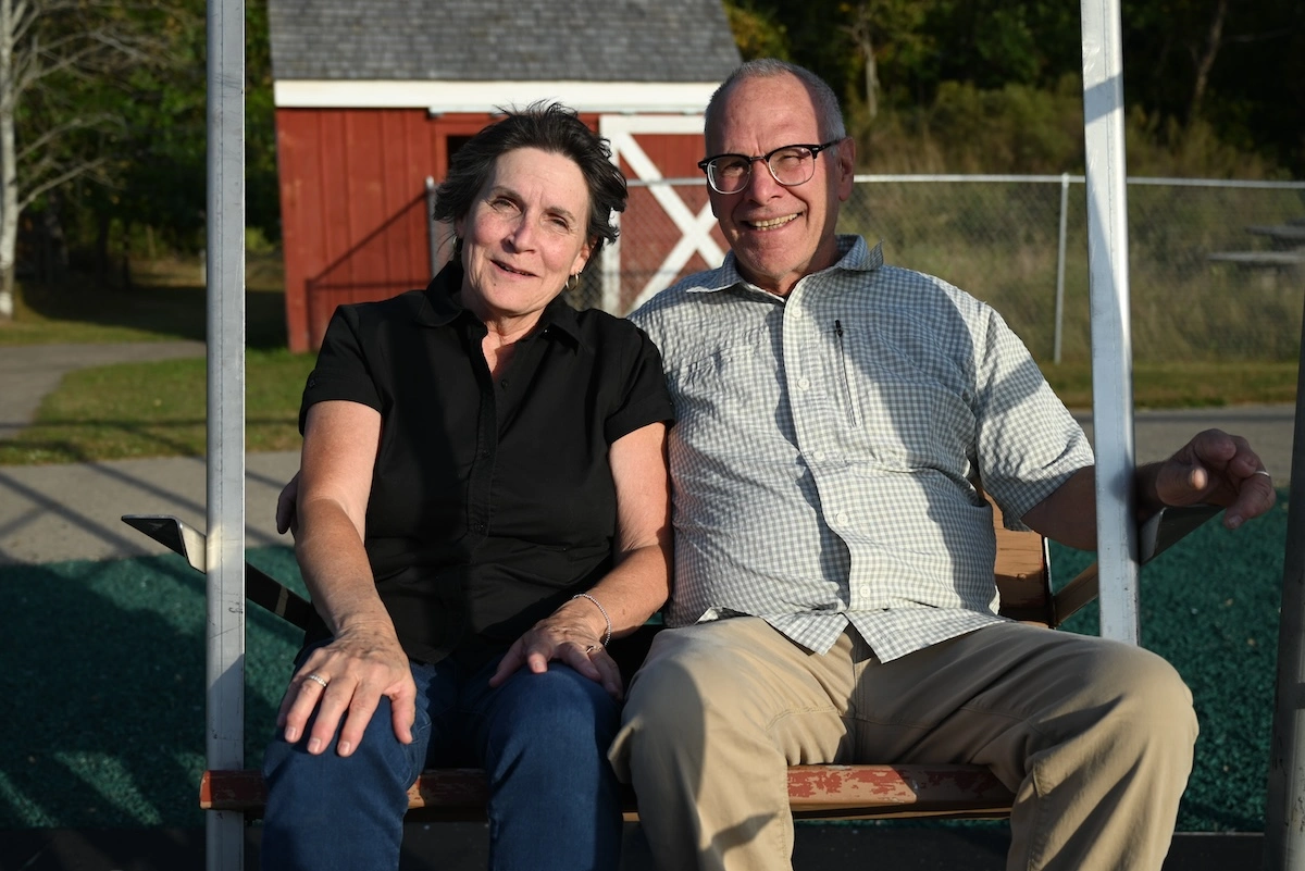 Patty Closser and Greg Closser sitting on swing together