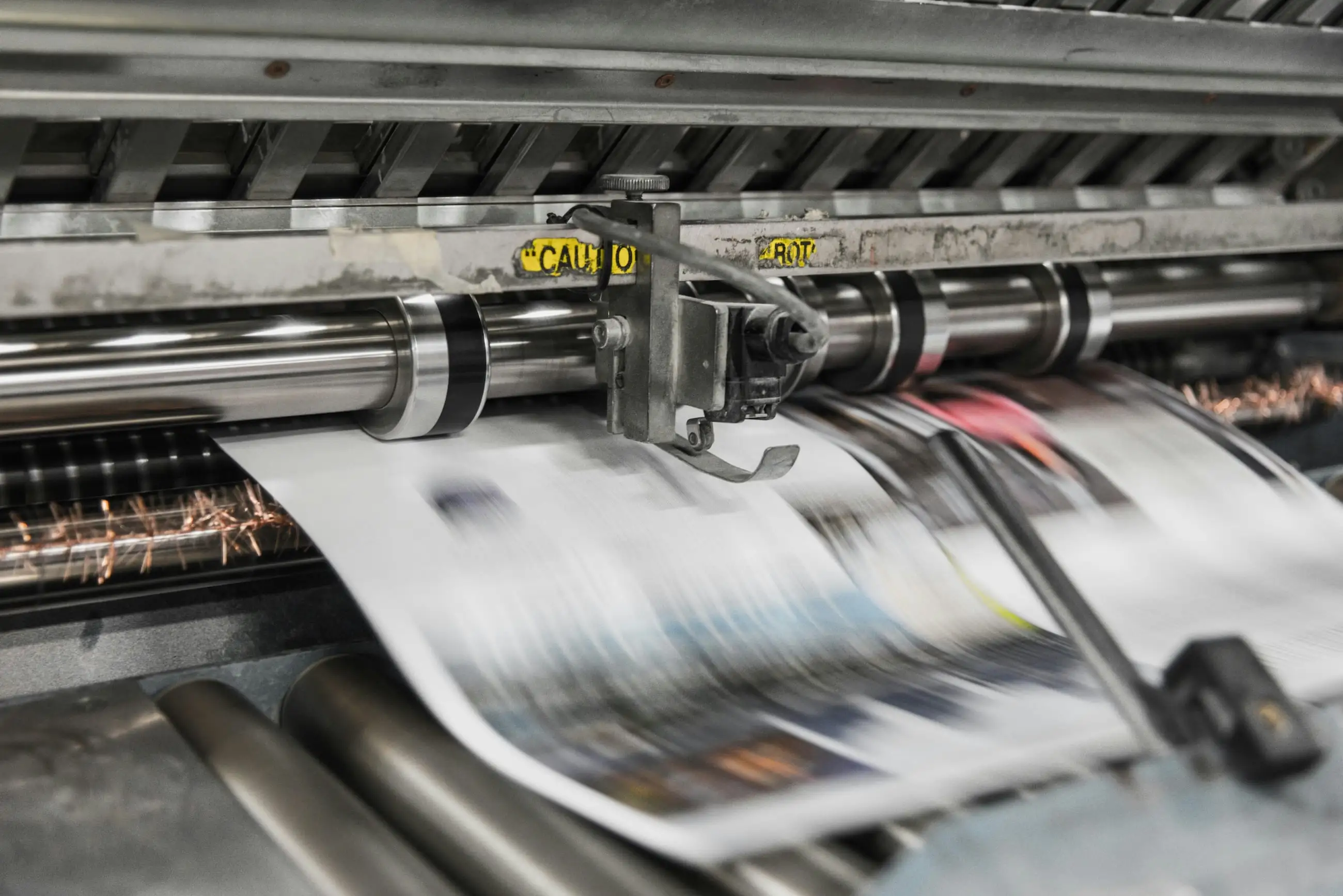 News papers moving fast while being made in a news press.